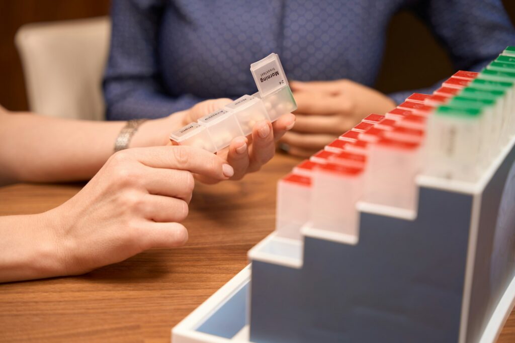 Medical worker holding multi-colored case for pills